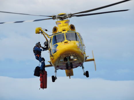 Action-packed scene of a rescue helicopter saving a person in midair, against a clear blue sky.