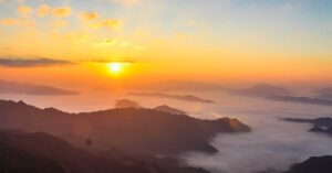 Stunning sunrise scene with mist-covered valleys and majestic mountain landscape.